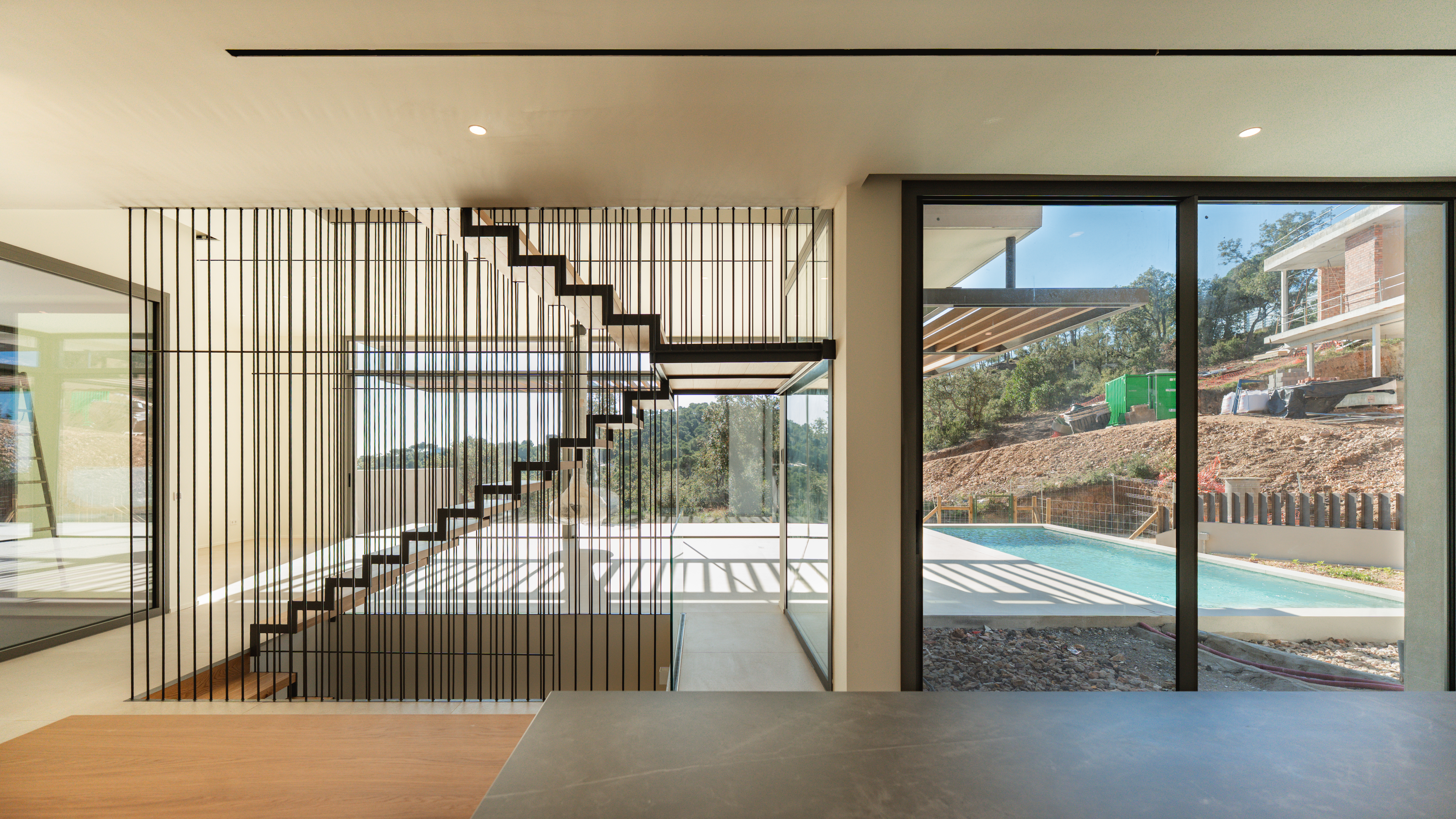 Living and staircase with pool view