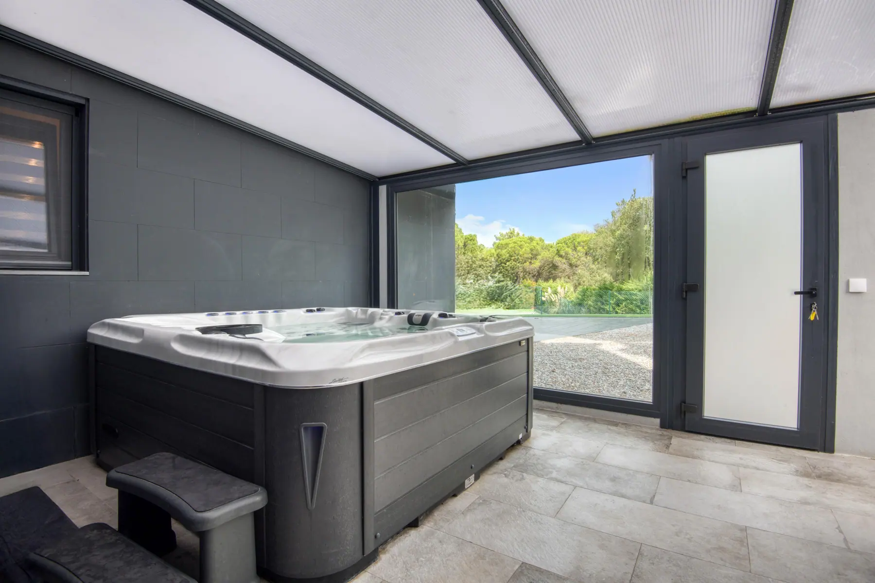 Indoor jacuzzi with a glass wall to the garden