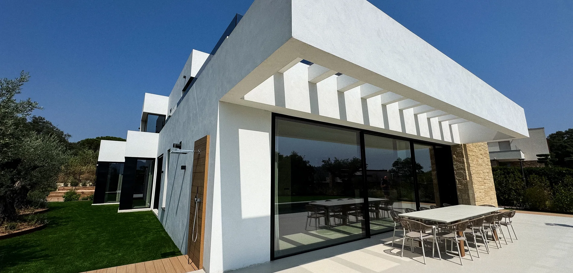 Villa Santa Cristina from the garden — white volumes, stone and the covered terrace