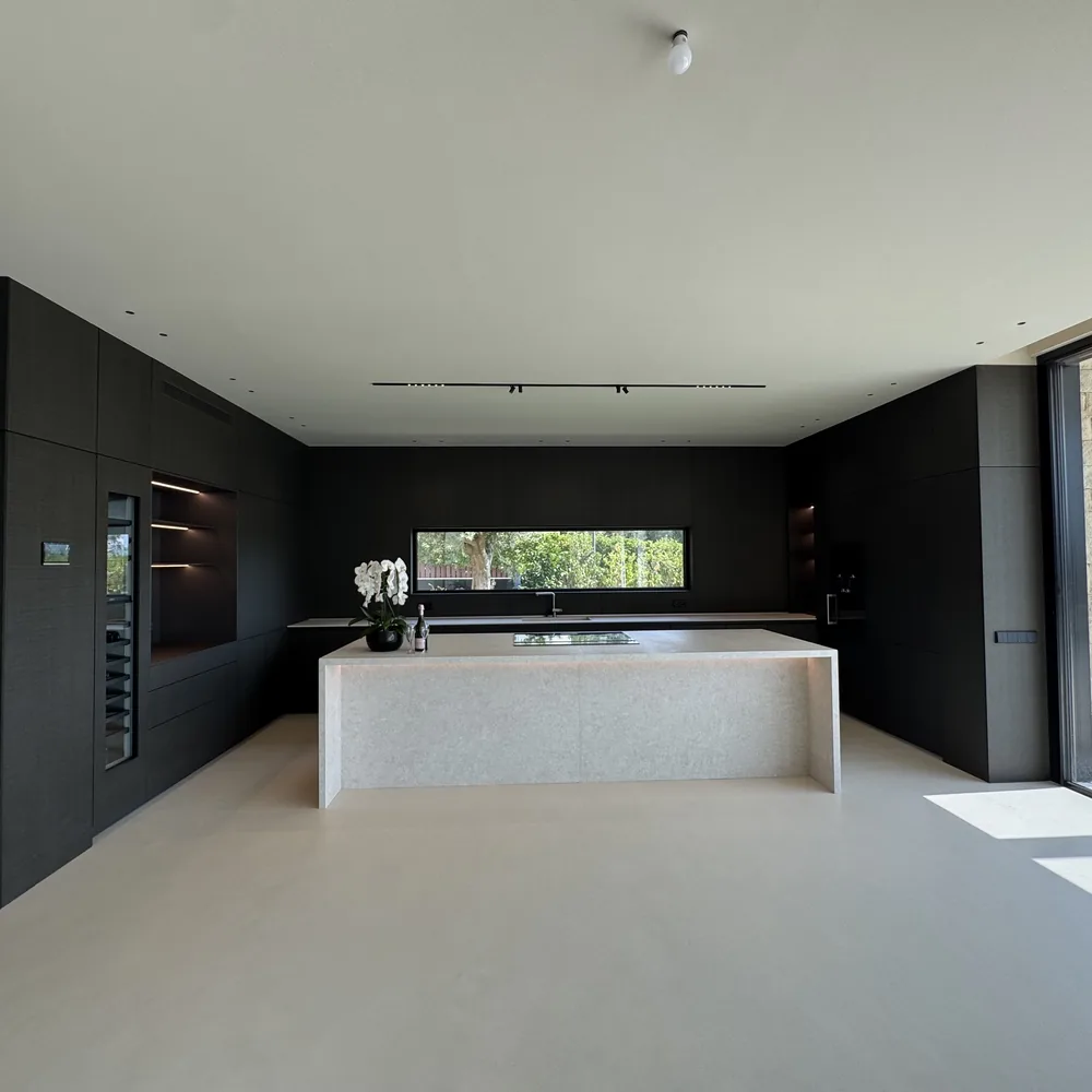 The kitchen from the hall, island and dark joinery