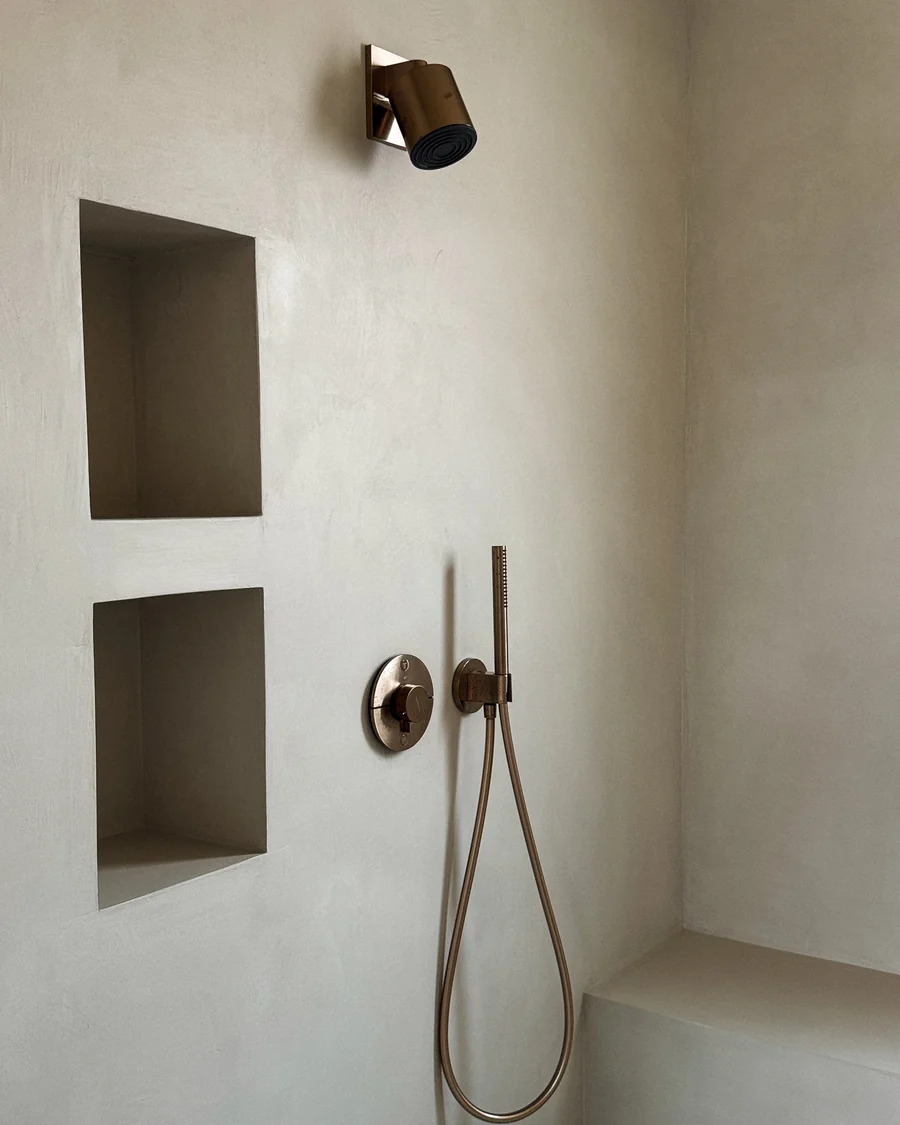 Shower in seamless plaster with brushed bronze fittings