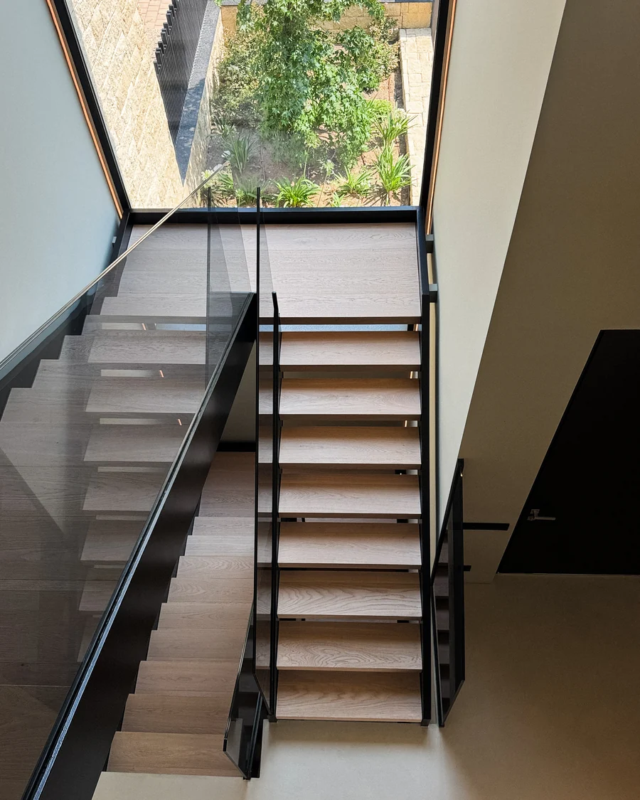 Open staircase in oak and steel with a glass balustrade