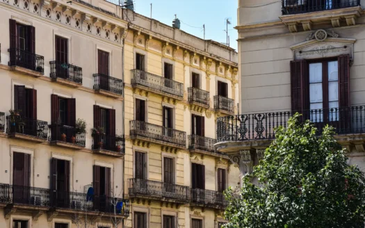 Residential buildings with balconies and closed shutters in Barcelona