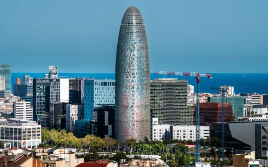 Torre Glòries and office buildings in Barcelona's 22@ business district, with the sea behind